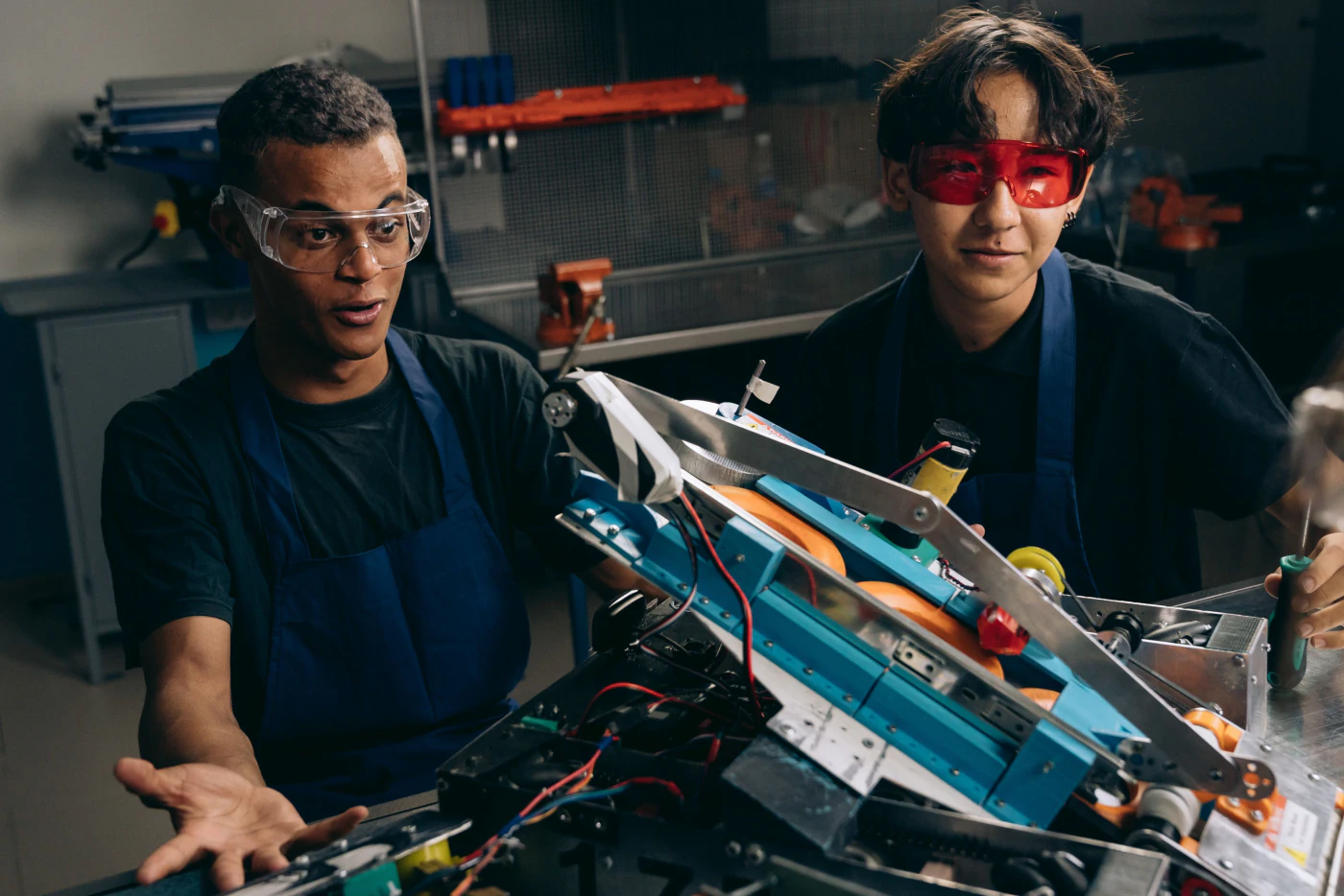 Two engineers examining robotics hardware on a workbench